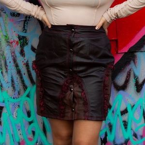 Brown leather skirt with garter like laced panels. Snap front closure.